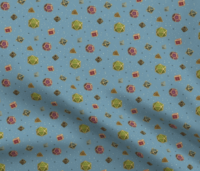 A repeating pattern of a set of 7 Dungeons and Dragons Dice in jewel tones with gold edges, on a medium blue background, surrounded by little yellow stars and small shiny orbs in dark blue. The pattern is demoed in a small size on a rippling piece of fabric.