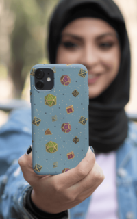 A repeating pattern of 7 Dungeons and Dragons Dice in bright colors: green, magenta, brown, blue, black, turquoise, and pink, each with gold trim and numbers, on a light blue background, demoed on an iphone 12 held by a muslim woman taking a selfie.