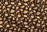 A repeat pattern of fall related elements in orange, drawn with outlines that shift between multiple shades of red, orange and yellow. There are several types of leaves, small pumpkins, a squash, pinecones, and acorns. The background is brown with a series of darker brown triangles. The pattern is demoed on a piece of rippling fabric.