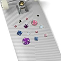 A set of 13 stickers, ranging half an inch to an inch wide, of the 7 Dungeons and Dragons Dice in the colors of the genderfluid pride flag: blue, purple, white, pink and black. The stickers are transparent and are on the back of a silver skateboard.