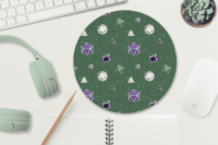 A repeating pattern of 7 Dungeons and Dragons Dice in genderqueer pride flag colors: Purple, white, and green on a dark green background. It is demoed on a circular mousepad next to a computer and mint green headphones.