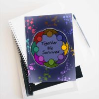 A hard cover journal with a drawing of a glowing circle of people with joined arms, in a rainbow of colors with matching sparkles flowing out of each, surrounding a blue background and the words Together We Survived, on a background of dark blue.