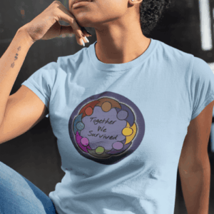A drawing of a glowing circle of people with joined arms, in a rainbow of colors, surrounding a blue background and the words Together We Survived. It is on a light blue T-shirt worn by a thoughtful black woman with glasses and short natural hair.