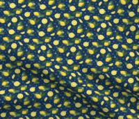 A repeat pattern of lemons, lemon slices, and lemon wedges, interspersed with green leaves, ferns, small dark and light blue flowers. The background is dark blue with small blue dots. The pattern is demoed in a small size on a piece of rippling fabric.