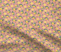 A repeat pattern of lemons, lemon slices, and lemon wedges, interspersed with green leaves, ferns, small red flowers, and small pink flowers. The background is salmon with small pink dots. The pattern is demoed in a small size on a piece of rippling fabric.